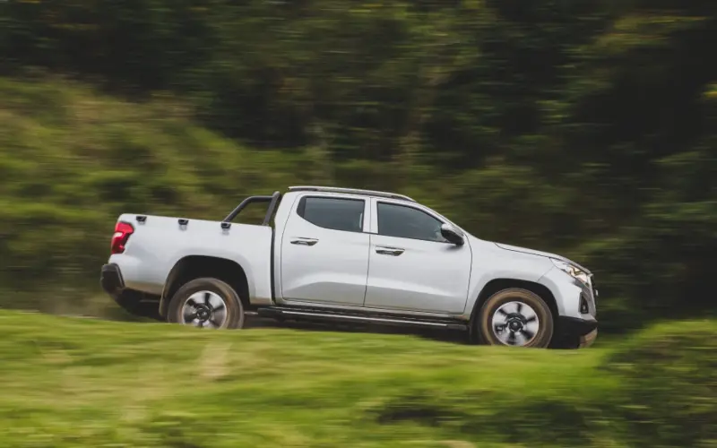 Camioneta pickup Changan Hunter gris de cuatro puertas, desplazándose por un camino rural